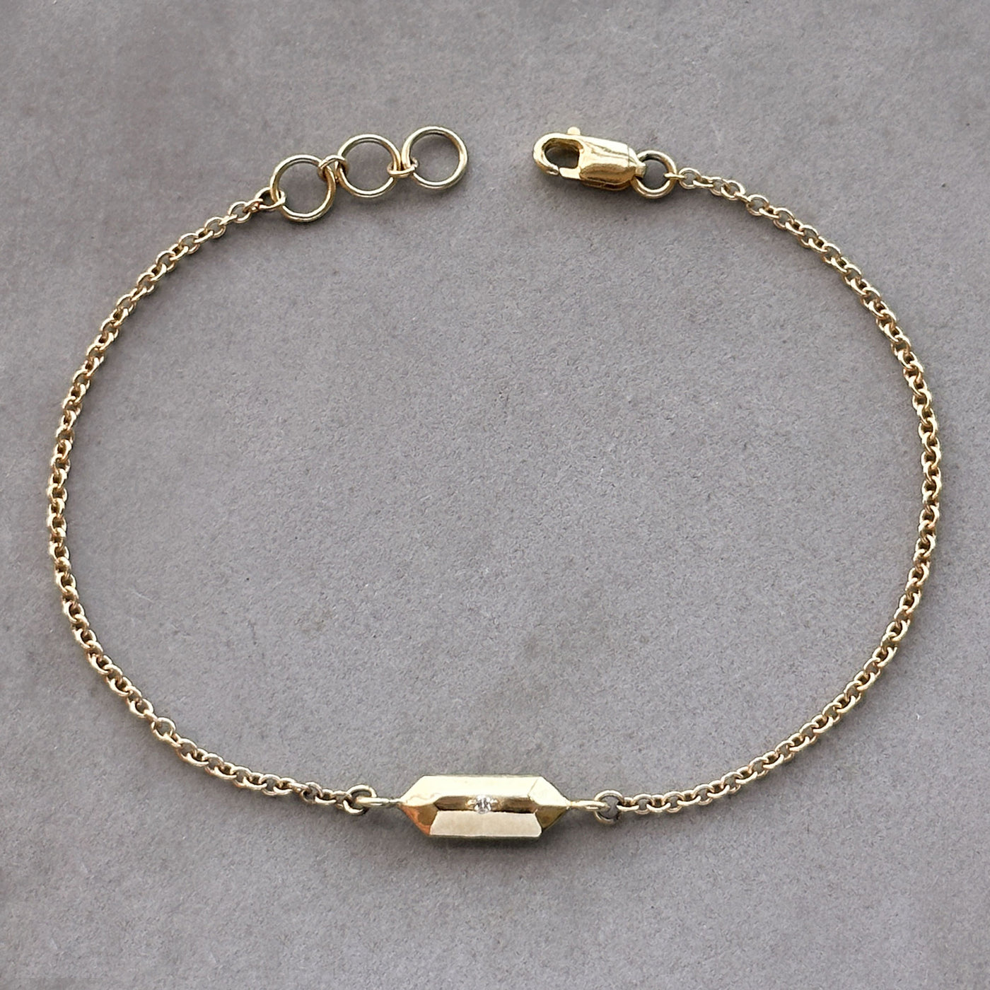 Fragment Chain Bracelet with Diamond in Gold on a gray background