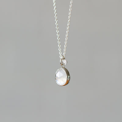 Rose Cut Moonstone Silver Theia Necklace #9 hanging in front of a white wall, side angle