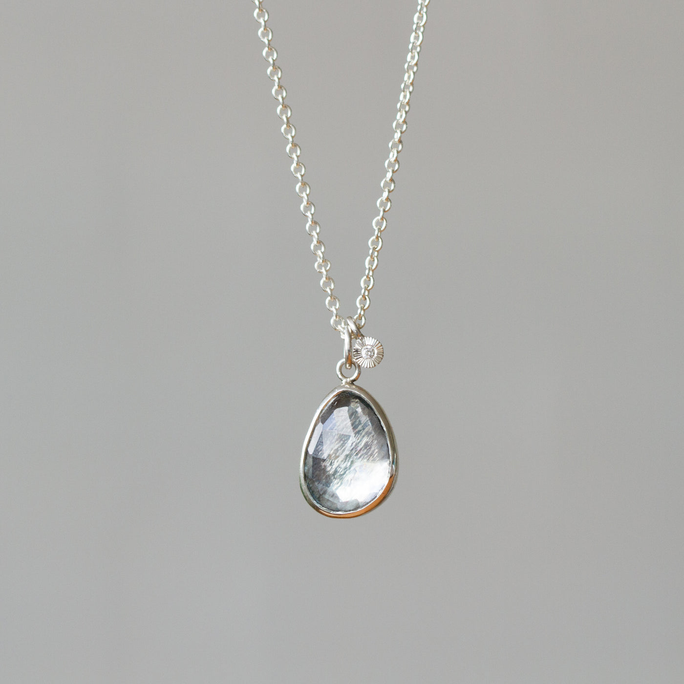 Rose Cut Moss Aquamarine Silver Theia Necklace #9 hanging in front of a wall, front angle