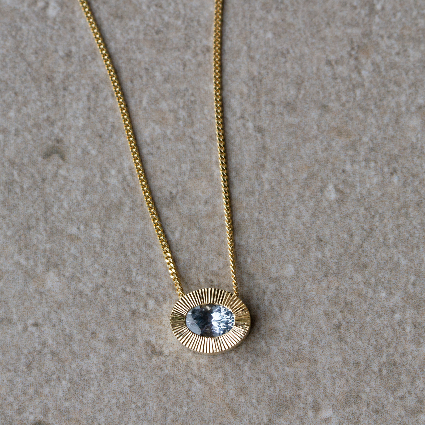East-West Oval Aurora Necklace with Silver Montana Sapphire in Yellow Gold on a neutral background