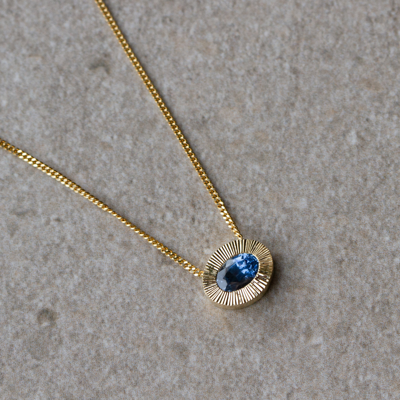 East-West Oval Aurora Necklace with Blue Montana Sapphire in Yellow Gold on a neutral background, front angle