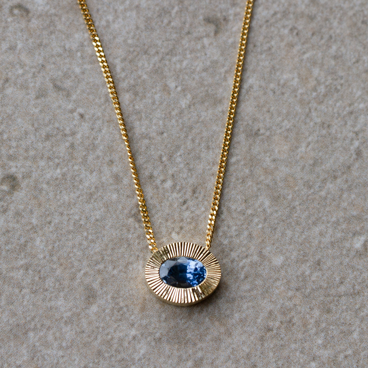 East-West Oval Aurora Necklace with Blue Montana Sapphire in Yellow Gold on a neutral background