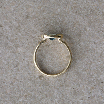 East-West Aurora Solitaire with Teal Oval Montana Sapphire on a neutral background, from the side