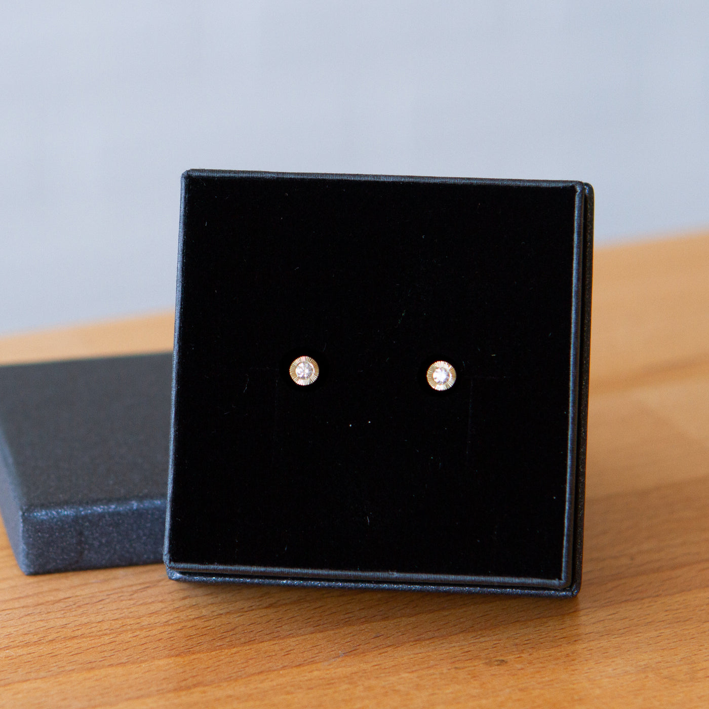 Medium Diamond Aurora stud earring in yellow gold with an engraved halo border in a gift box