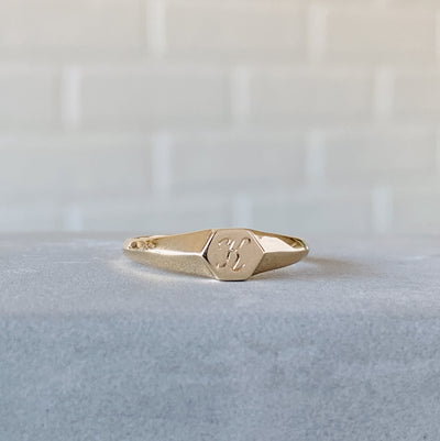 Low profile gold signet ring with hexagon top and engraved single script "K" initial