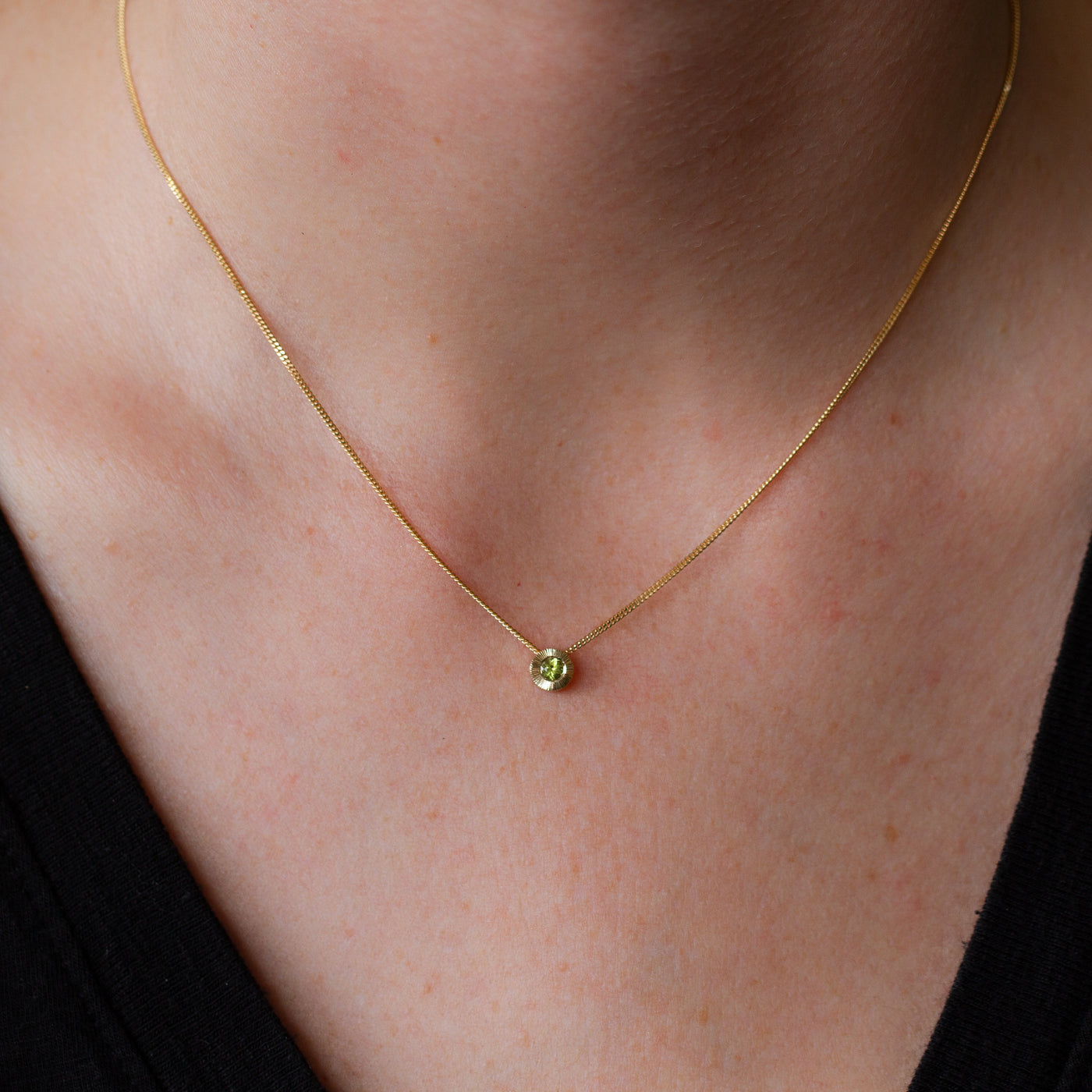 August birthstone Aurora slide necklace with peridot in gold on a neck