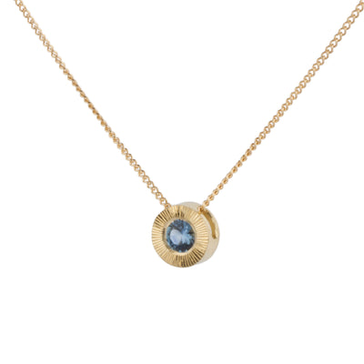 Side View 14k yellow gold Medium aurora necklace with a denim blue Montana sapphire center and engraved halo border on a white background