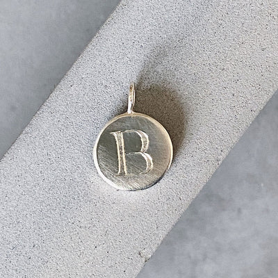 Sterling silver round pendant with an engraved block letter B