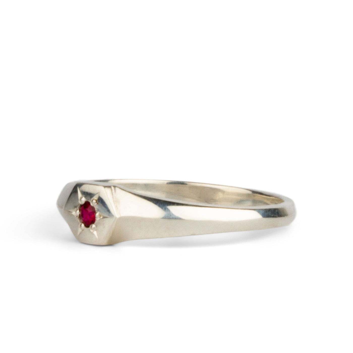 Side view sterling silver hexagon signet ring with a star set ruby in the center on a white background