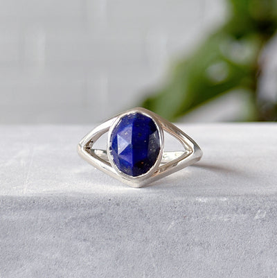 Oval rose cut Lapis Cleo Silver Ring #1 sitting in front of a white wall, front angle