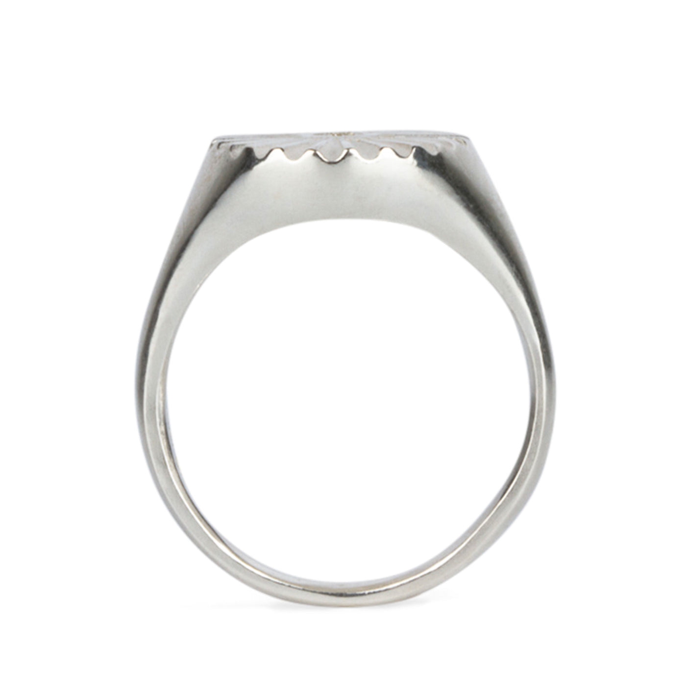 Profile view of Large silver oval signet ring with a carved sunburst pattern and diamond center on a white background