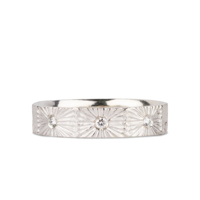 Nova sunburst eternity band with 8 flush set diamonds and carved texture around the outside in sterling silver