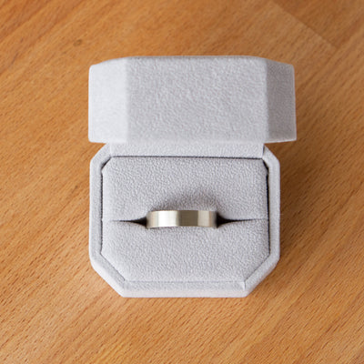 Wide Diablo flat brushed white gold wedding band in a ring box