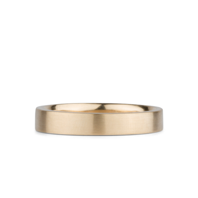 4mm Wide Diablo flat brushed yellow gold wedding band on a white background by Corey Egan