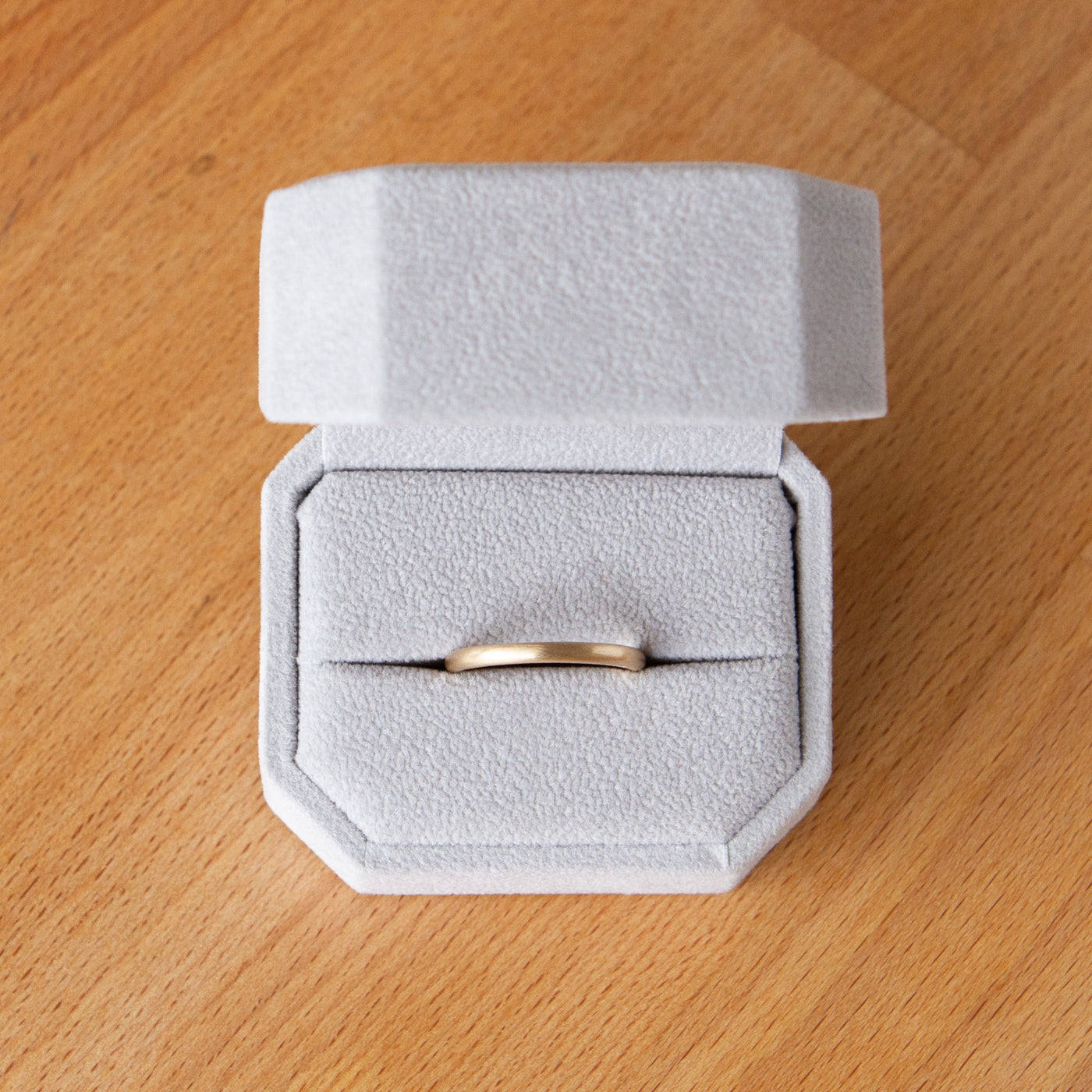 Thin half round Diablo yellow gold brushed wedding band in a ring box