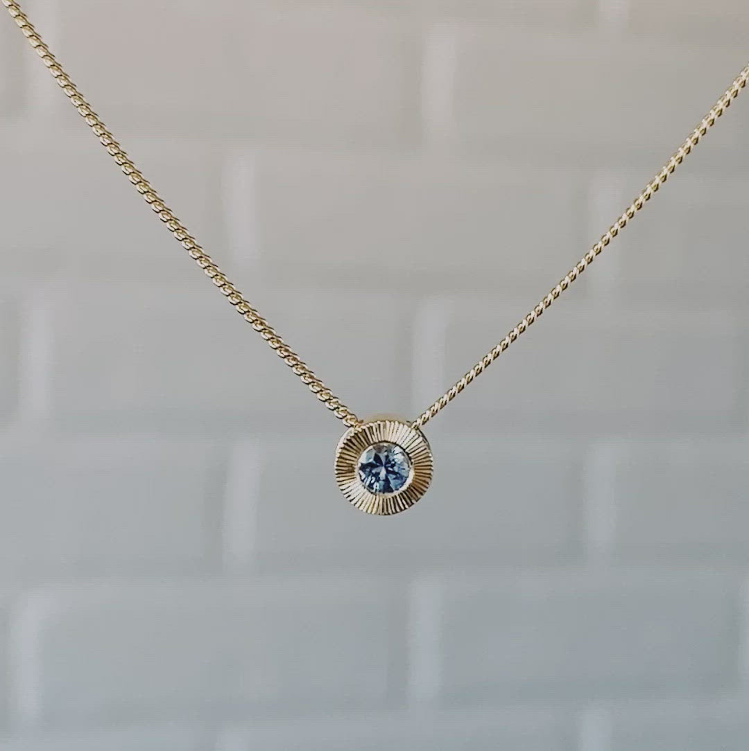 14k yellow gold small aurora necklace with a denim blue Montana sapphire center 