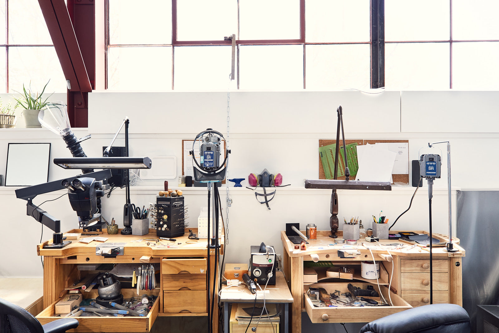 Two slightly messy jewelry workbenches side by side