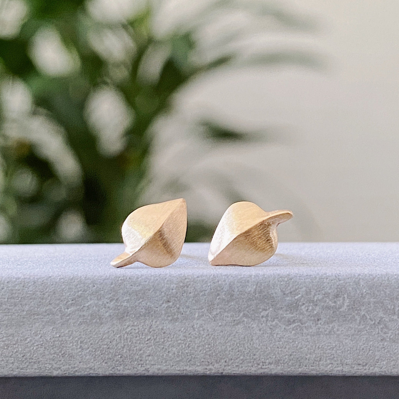 Yellow Gold Aspen Stud Earrings on concrete by Corey Egan