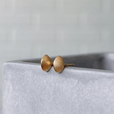 Vermeil Dewdrop Studs displayed on a concrete table, side angle