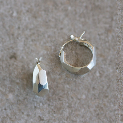 Silver Fragment Huggie Hoops on a natural background, side angle