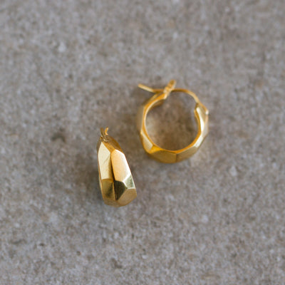 Vermeil Fragment Huggie Hoops on a natural background, side angle