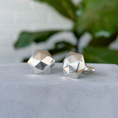 Fragment Cufflinks sitting on a concrete wall, side angle