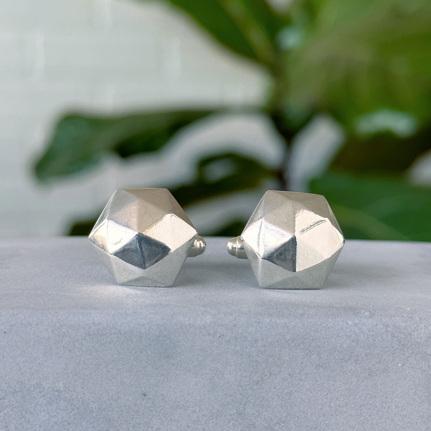 Fragment Cufflinks sitting on a concrete wall, front angle