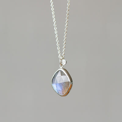 Rose Cut Labradorite Silver Theia Necklace #12 hanging in front of a white wall, side angle