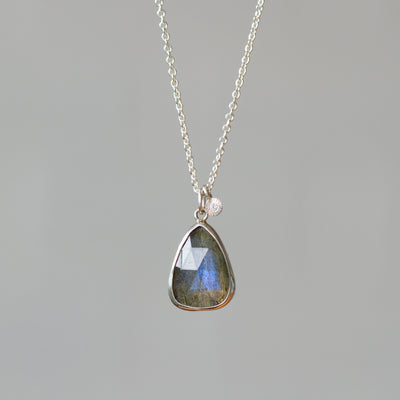 Rose Cut Labradorite Silver Theia Necklace #13 hanging in front of a white wall, front angle