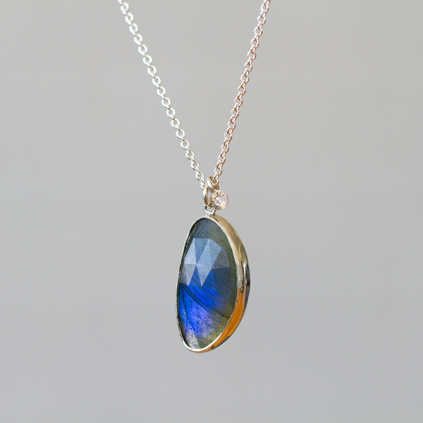 Labradorite Silver Theia Necklace #16 hanging in front of a plain background, side angle