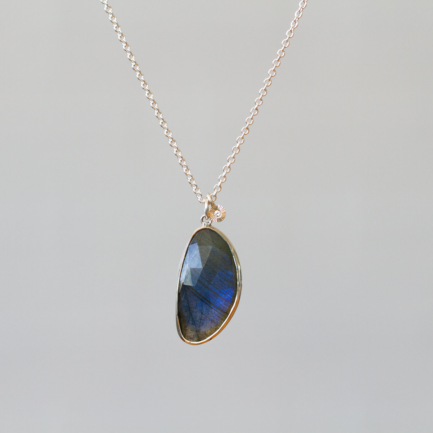 Labradorite Silver Theia Necklace #16 hanging in front of a plain background, front angle