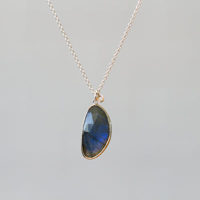 Labradorite Silver Theia Necklace #16 hanging in front of a plain background, front angle