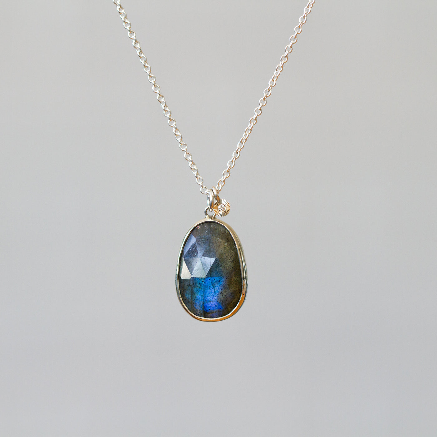 Labradorite Silver Theia Necklace #17 hanging in front of a plain background, front angle