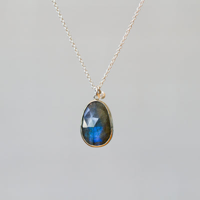 Labradorite Silver Theia Necklace #17 hanging in front of a plain background, front angle