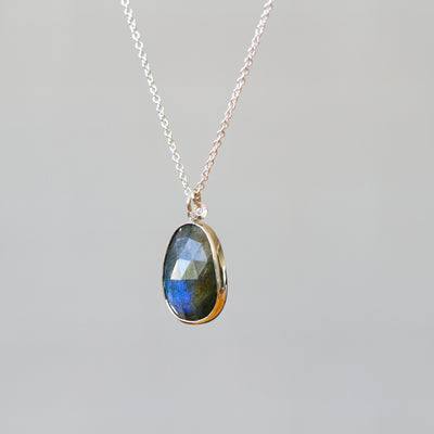 Labradorite Silver Theia Necklace #17 hanging in front of a plain background, side angle