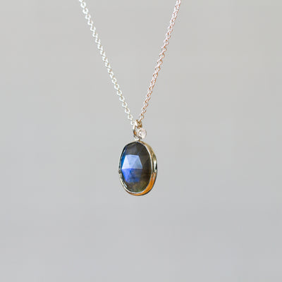 Labradorite Silver Theia Necklace #18 hanging in front of a plain background, side angle