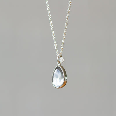 Rose Cut Moss Aquamarine Silver Theia Necklace #9 hanging in front of a wall, side angle