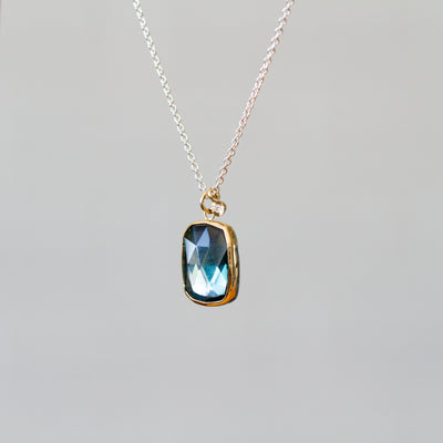 London Blue Topaz Silver and Gold Theia Necklace #8 on a plain background, side angle