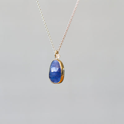 Tanzanite Silver and Gold Theia Necklace on a plain background, side angle