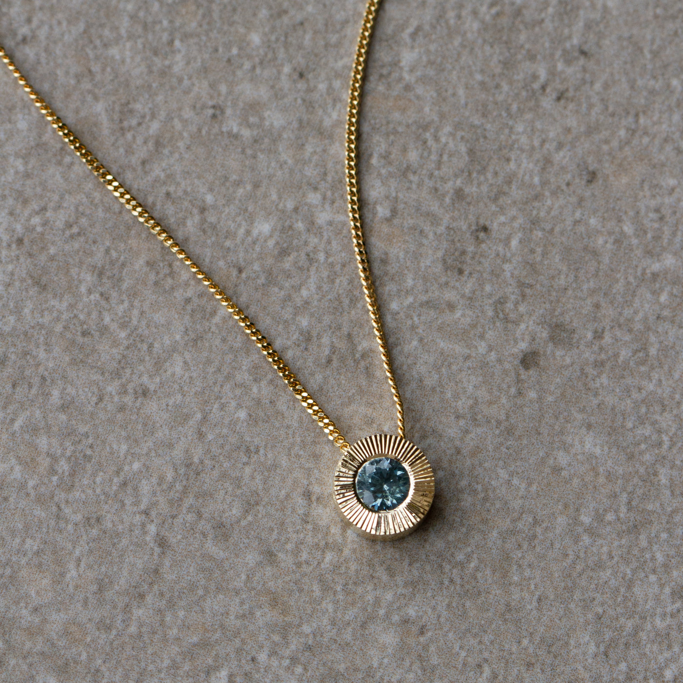 Light Green Montana Sapphire Medium Aurora Necklace in Yellow Gold on a neutral background, side angle