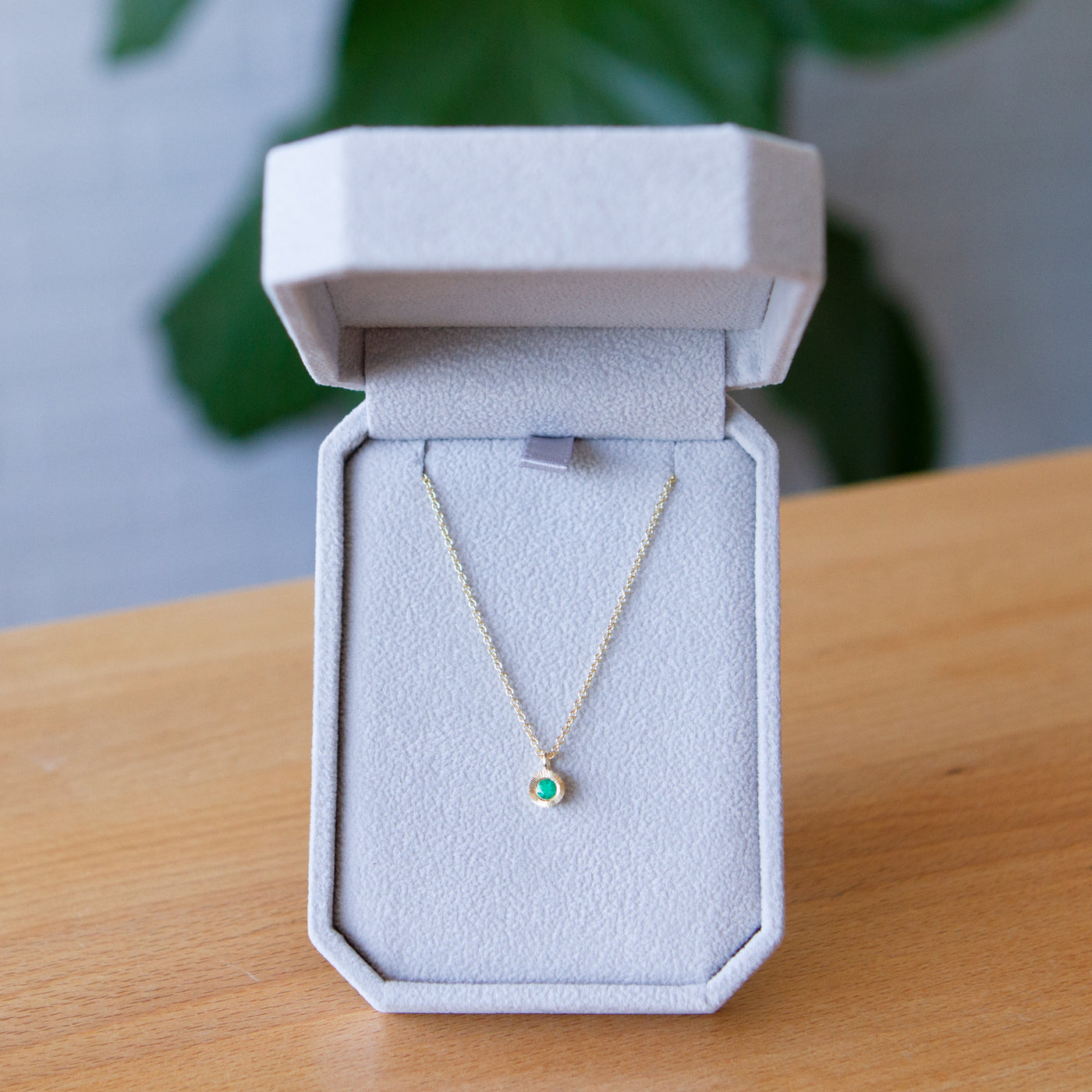 Emerald Small Aurora Pendant Necklace in Yellow Gold packaged in a gray jewelry box