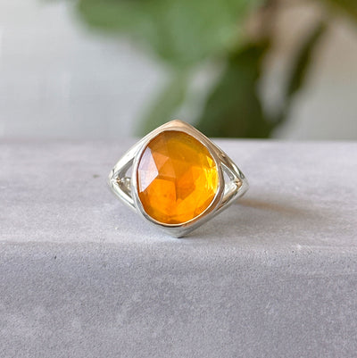 Fire Opal Cleo Ring in Sterling Silver #1 on a concrete table, front angle