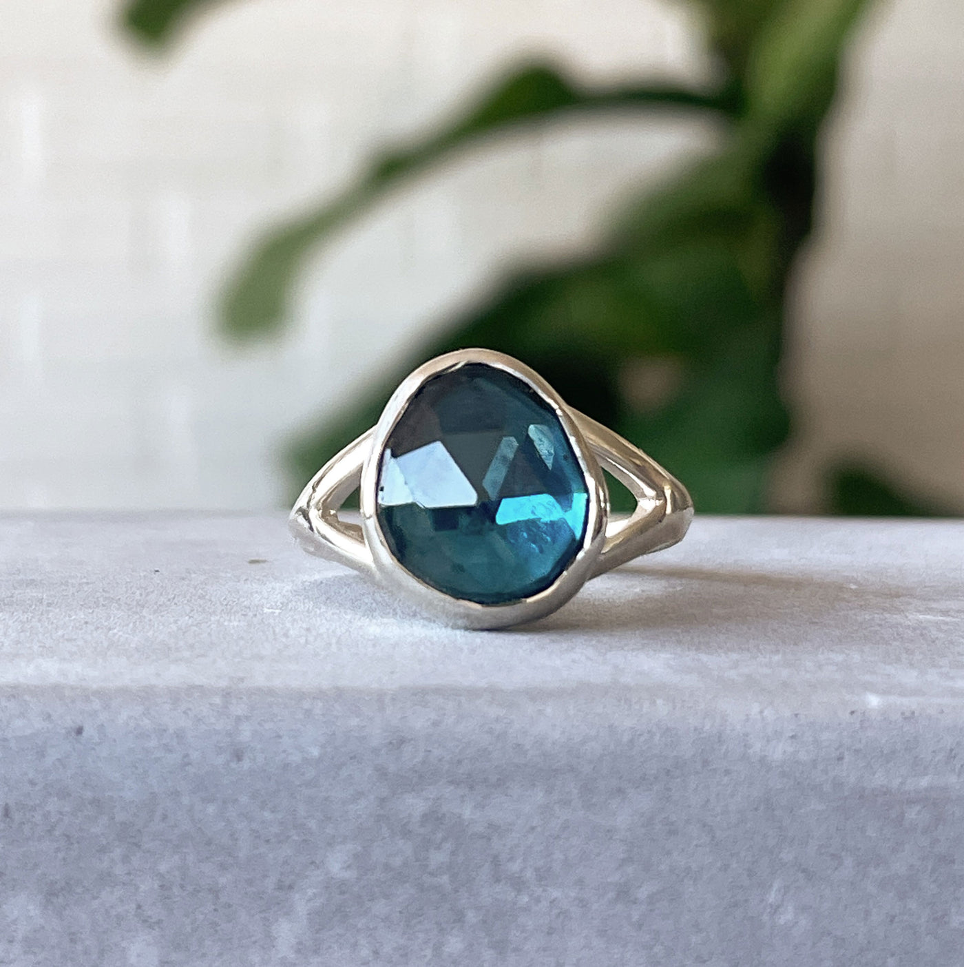 London Blue Topaz Cleo Ring in Sterling Silver #8 on a concrete wall, front angle