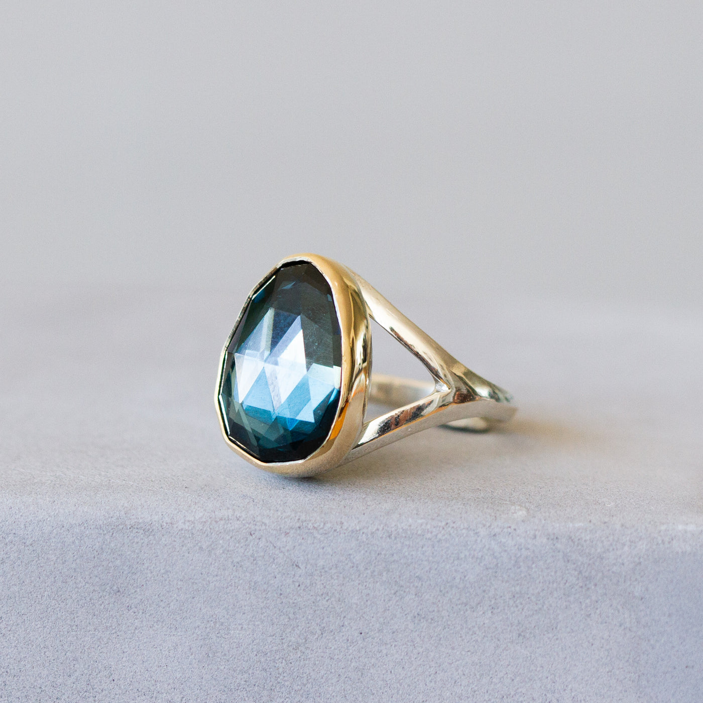 London Blue Topaz Silver and Gold Cleo Ring #7 in front of a plain background, side angle