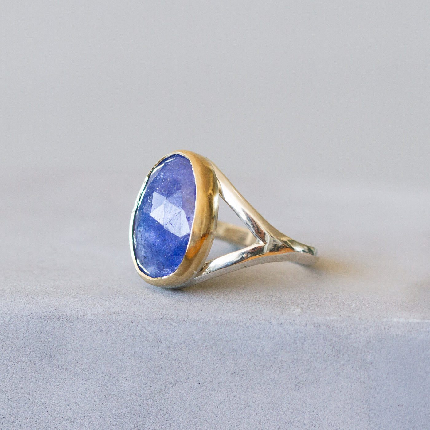 Tanzanite Silver and Gold Cleo Ring on a plain background, side angle