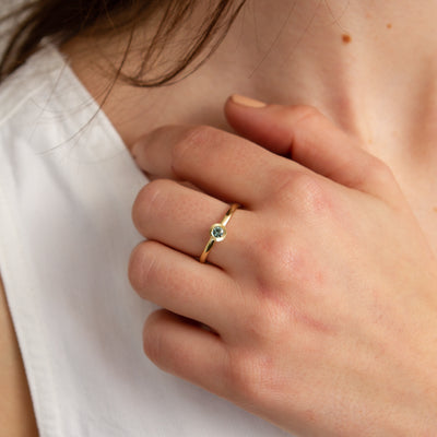 Teal Montana Sapphire Large Aurora Stacking Ring in Yellow Gold modeled on a finger
