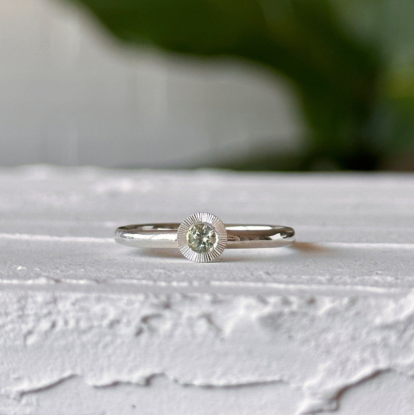Light Green Montana Sapphire Large Aurora Stacking Ring in Silver sitting on a white table, front angle 