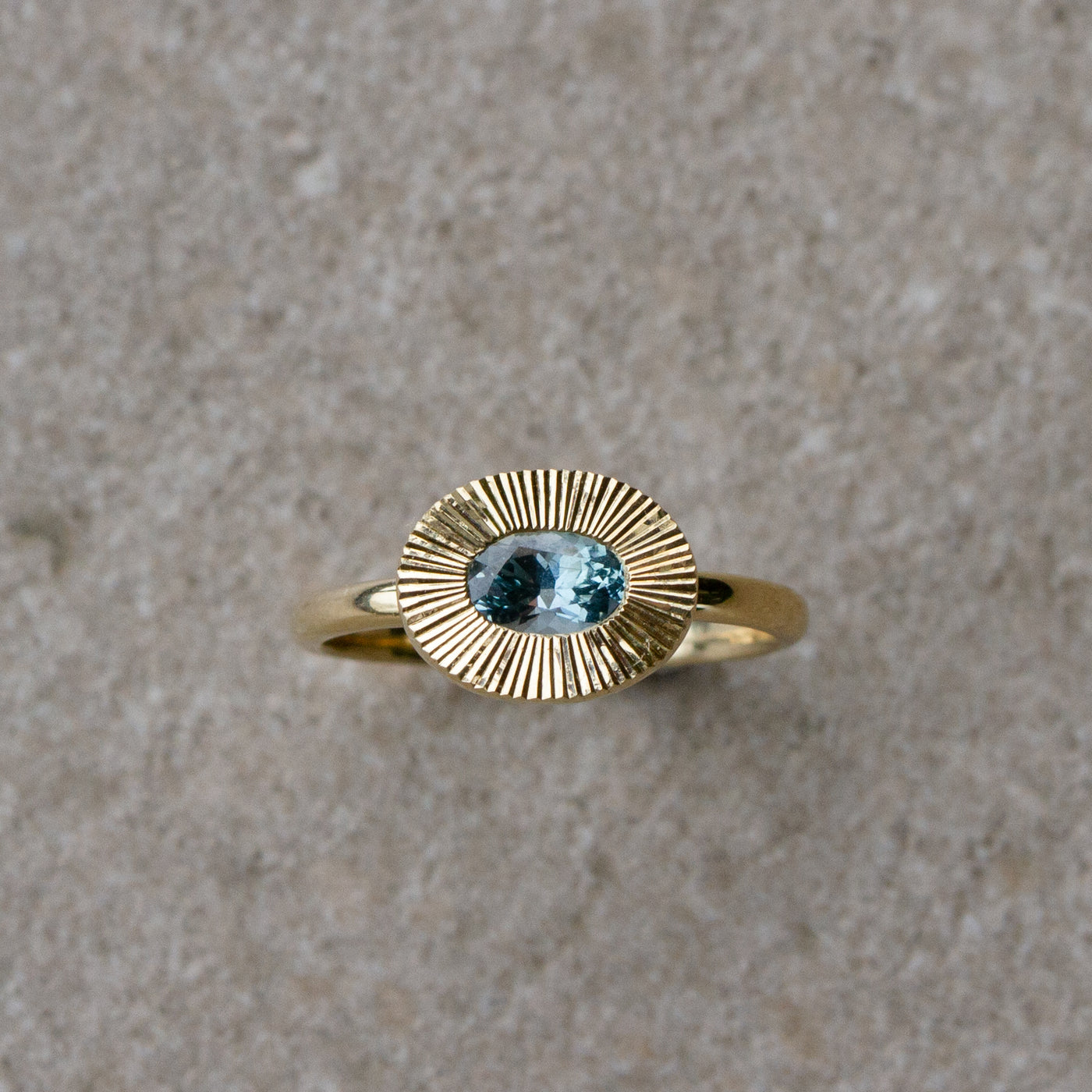 East-West Aurora Solitaire with Teal Oval Montana Sapphire on a neutral background