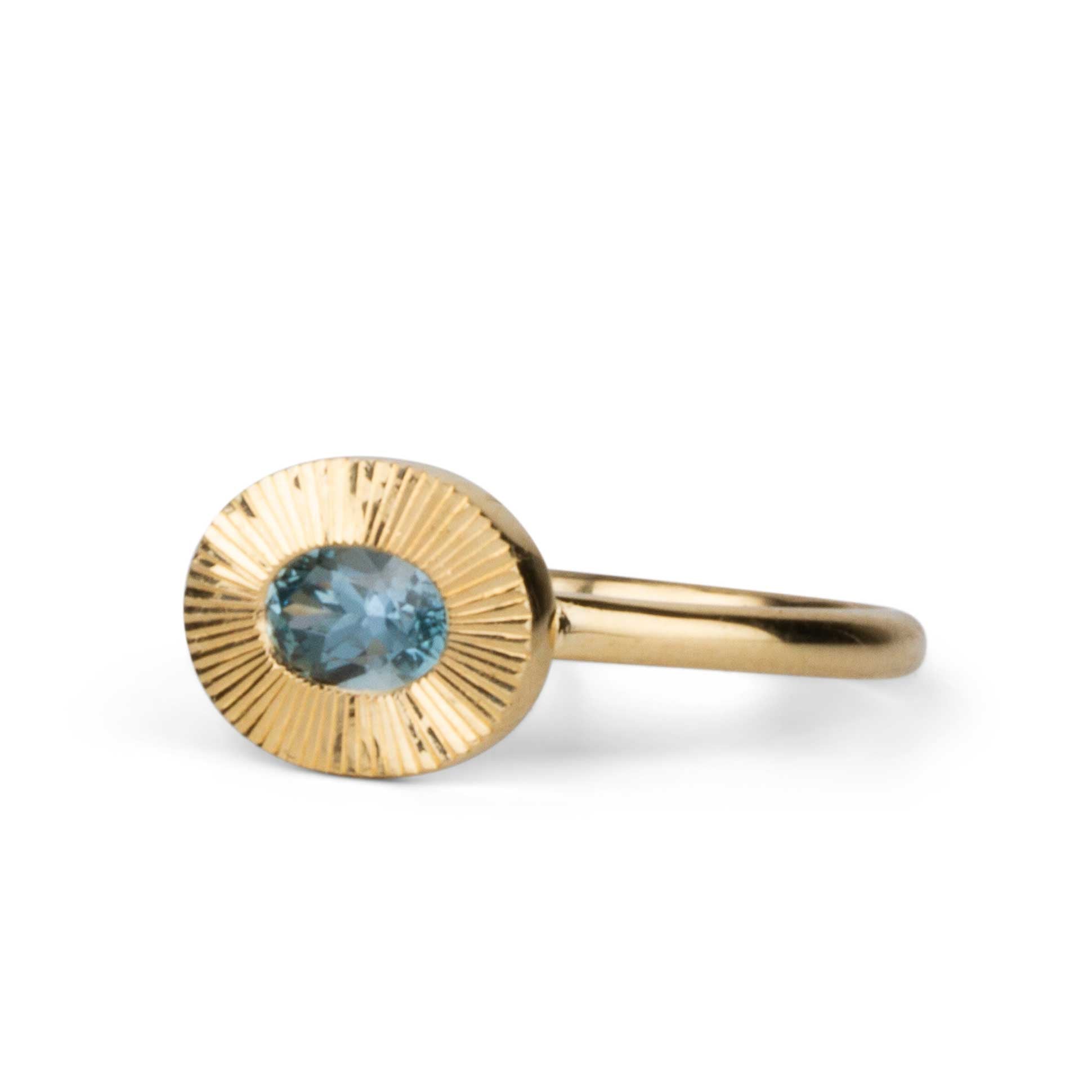 East-West Aurora Solitaire with Teal Oval Montana Sapphire on a white background, side angle