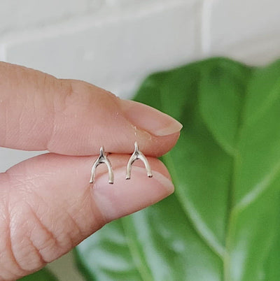 Silver Wishbone Stud Earrings held between two fingers
